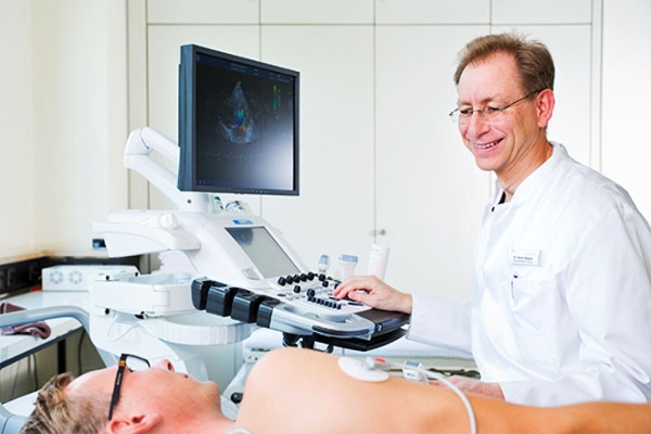 Ein Arzt macht bei einem Patienten eine Ultraschall-Untersuchung.